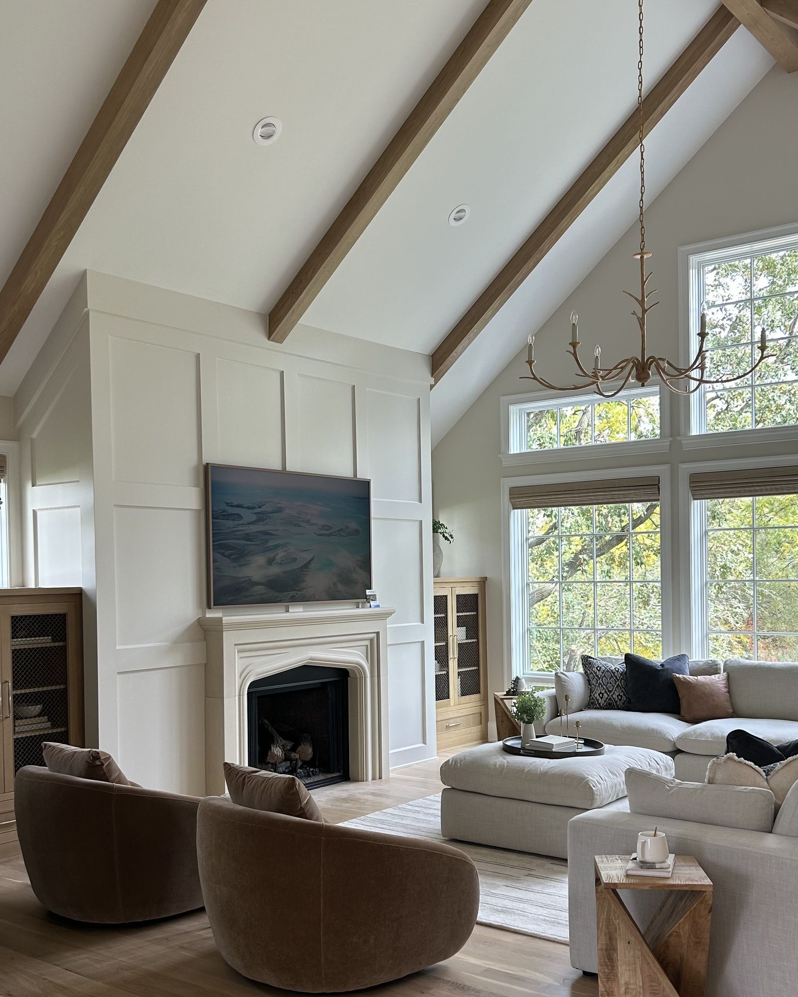 South Lane great room, with a vaulted beamed ceiling and a paneled fireplace wall with a Tudor-arched stone mantel